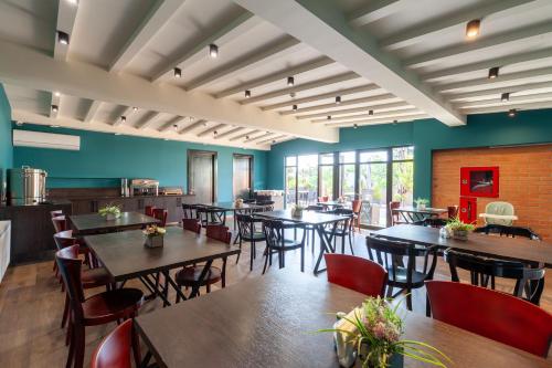 a restaurant with wooden tables and chairs and blue walls at Hotel InnDigo in Kutaisi in Kutaisi
