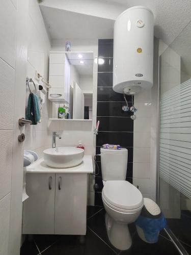 Un baño con un inodoro blanco y un lavabo. en Maksimilijan, en Ohrid