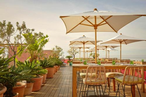 a patio with tables and chairs and umbrellas at AC Hotel by Marriott Nice in Nice