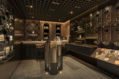 a restaurant with a counter and a bar with vases at Sankara Nairobi, Autograph Collection in Nairobi