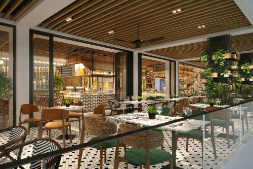 a restaurant with tables and chairs and windows at Sankara Nairobi, Autograph Collection in Nairobi