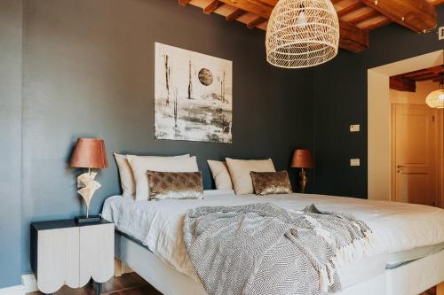 a bedroom with a large white bed and a wall at Maniero Montecassiano in Montecassiano