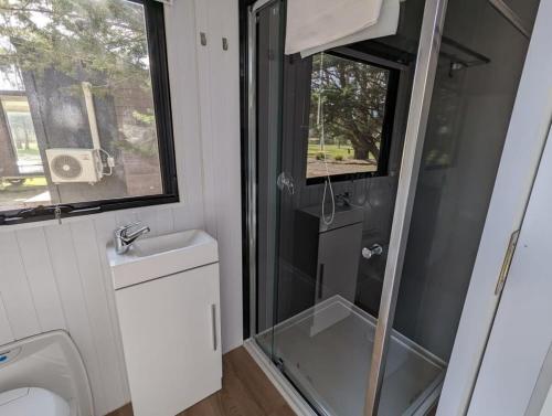 a bathroom with a shower and a toilet and a sink at Tiny Homes Escape at Grampians Edge by Tiny Away in Dadswells Bridge
