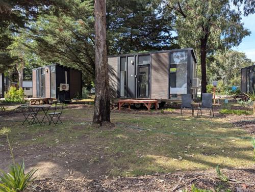a tiny house sitting in a yard next to a tree at Tiny Homes Escape at Grampians Edge by Tiny Away in Dadswells Bridge