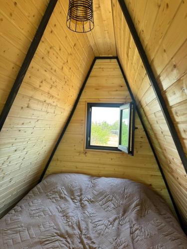 a bed in a wooden room with a window at Art House in Yerevan
