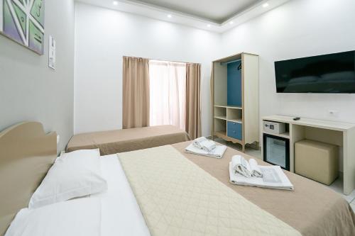 a hotel room with two beds and a television at Royal H Umberto I, Napoli Centro, by ClaPa Group in Naples
