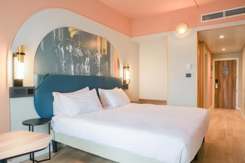 a bedroom with a large white bed and a table at Mercure Bologna Centro in Bologna