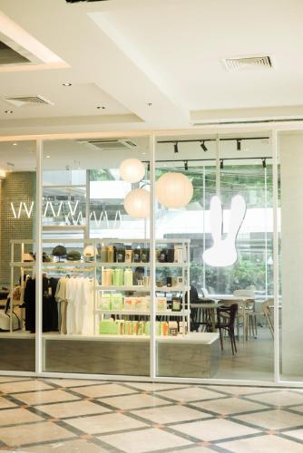 a store with glass doors and a table and chairs at The Quarter Saphankhwai by UHG in Bangkok