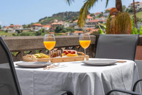 a table with two glasses of wine and a tray of food at Akosuah's Villa in Funchal