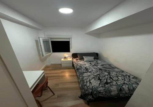 a small bedroom with a bed and a window at alojamiento near everything in Valencia