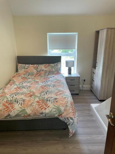 a bedroom with a bed with a comforter and a window at Corrandulla 2 Storey Home-3 Bedrooms in Galway