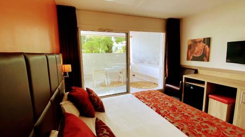 - une chambre avec un lit et une fenêtre avec une terrasse dans l'établissement Royal Cottage Pamela Hotel Cassis, à Cassis