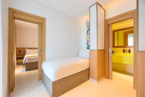 a small bedroom with a bed and a bathroom at Fuwairit Kite Beach, Tapestry Collection By Hilton in Fuwayriţ