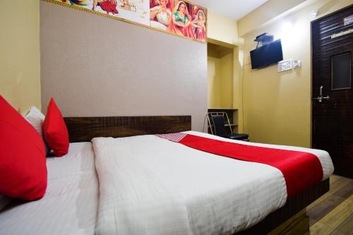 a hotel room with a bed with red pillows at Hotel O Kota Airport Formerly Vaishnavi in Kota