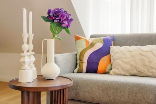 a living room with a couch and a table with vases at homie stay Dominikus in Würzburg