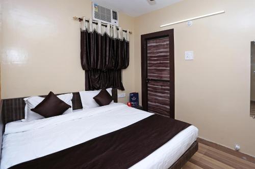 a bedroom with a large bed with black and white pillows at Hotel O Kota Airport Formerly Vaishnavi in Kota