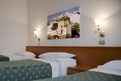 ScoppitoにあるHotel Aquilaのベッド3台付きの部屋