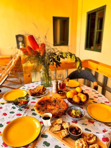 a table with yellow plates and food on it at Our Old House in Tʼelavi