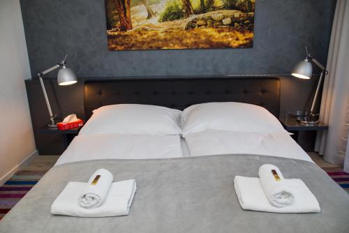 a bedroom with a bed with two towels on it at More Than Accommodation in Bratislava