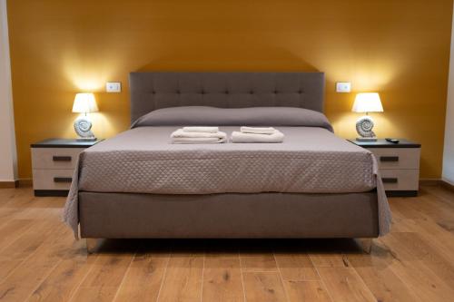 a bedroom with a large bed with two night stands at G&G Luxury Rooms in Bari