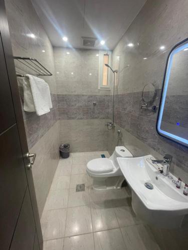 a bathroom with a toilet and a sink at جود المدينة للإجنحة الفاخرة in Medina