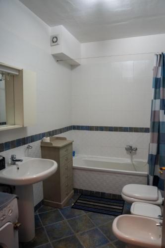 a bathroom with a sink and a toilet and a tub at La Maison de l'ile Bora in Policoro