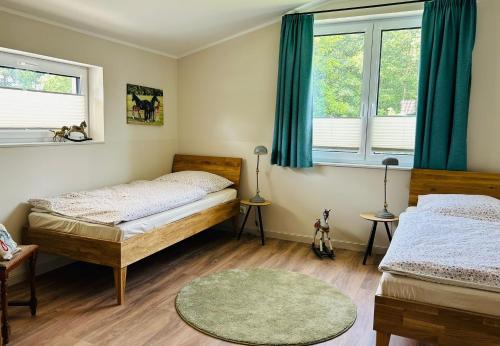 a bedroom with two beds and two windows at Ferienhaus Marie in Wittenbeck