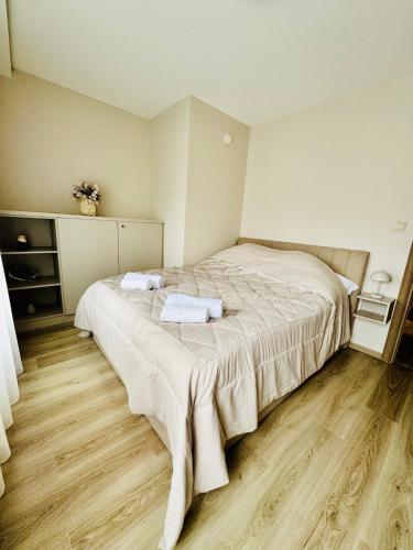 a bedroom with a bed with two towels on it at Evoli Apartman in Debrecen