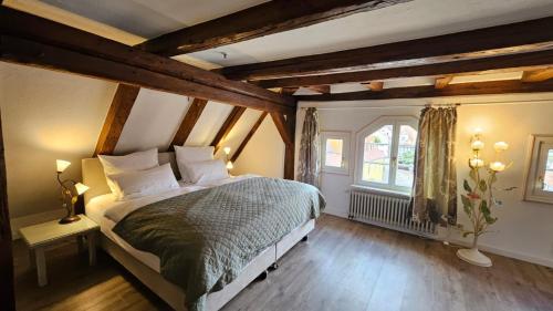 a bedroom with a large bed in a room with wooden ceilings at Altes Pfarrhaus Hotel und Restaurant in Bad Überkingen