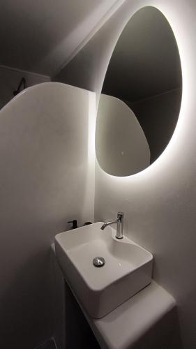a bathroom with a sink and a round mirror at Kanala Sea View in Kanala