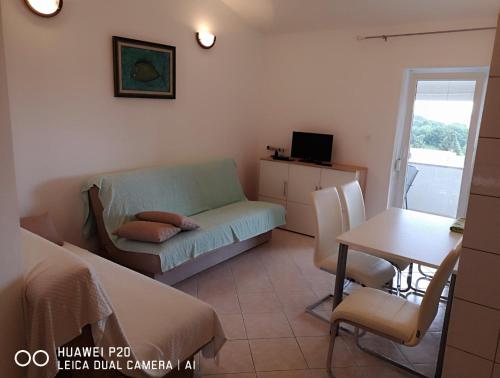 a living room with a couch and a table at Green Sea View Apartment in Premantura
