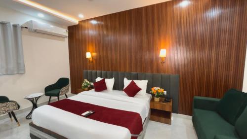 a hotel room with a bed and a green chair at Hotel The Tusk in Rishīkesh