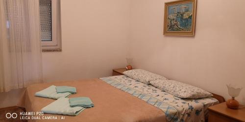 a bedroom with a bed with two towels on it at Green Sea View Apartment in Premantura