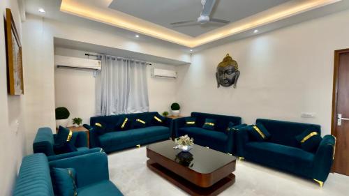 a living room with blue couches and a table at Hotel The Tusk in Rishīkesh