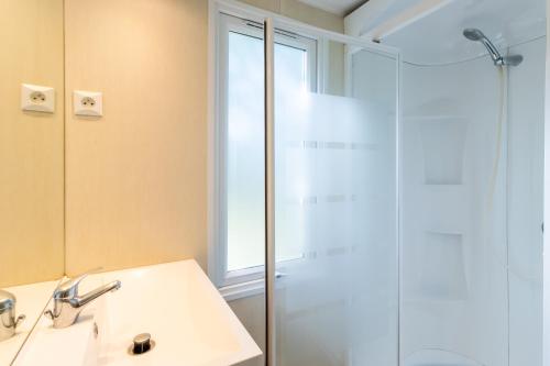 een badkamer met een wastafel en een douche bij Mobilhome du Soleil in Saint-Pompont