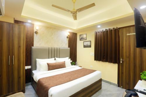 a bedroom with a large bed and a television at Hotel Mehak Palace By Aura in Noida