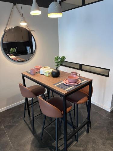 a dining room table with chairs and a mirror at Scartlez suites KLCC by Dream in Gua Sai