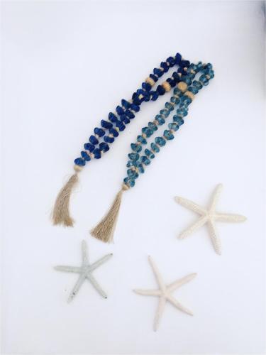 a beaded necklace with stars on a white background at Merchia Bay Villas Mykonos in Merchia Beach