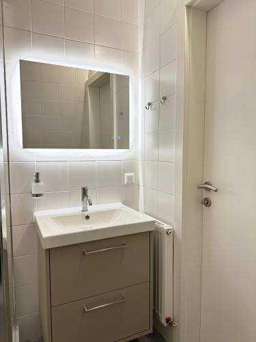 a white bathroom with a sink and a mirror at City Center Apartment in Sankt Pölten
