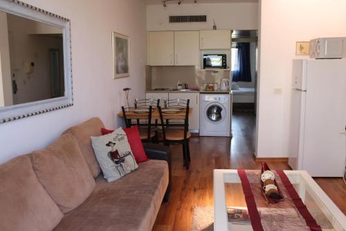 a living room with a couch and a dining room at Nomi Suites Marina Herzelia in Herzelia 