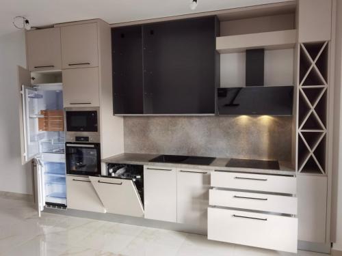 a kitchen with white cabinets and a refrigerator at Apartment L&L in Bar