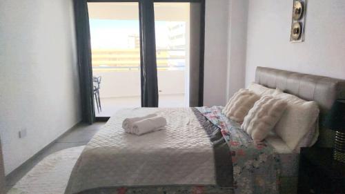 a bedroom with a bed with two rolled towels on it at LagunaSuite & More in Porlamar