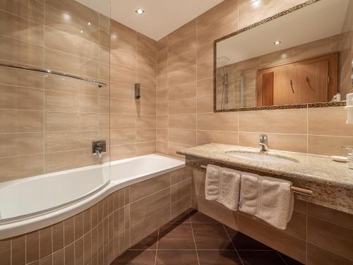 a bathroom with a tub and a sink and a mirror at Haus Annakogl und Haus Barbara in Obergurgl