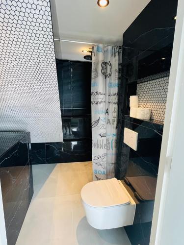 a bathroom with a toilet and a shower at Stijlvol en comfortabel appartement in rustige wijk in Nijmegen