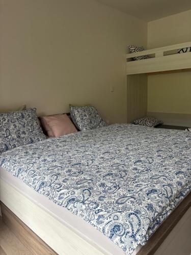 a bed with a blue and white comforter in a bedroom at Apartmán Mateřídouška in Cerny Dul