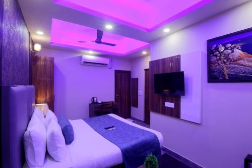 a purple room with a bed and a tv at Hotel Mehak Palace By Aura in Noida