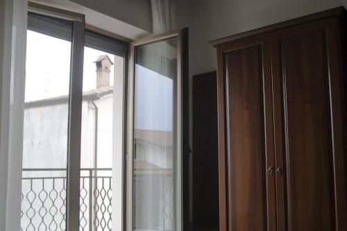 a room with a closet and a window with a balcony at Hotel Aquila in Scoppito