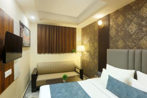 a hotel room with a bed and a couch at Hotel Mehak Palace By Aura in Noida