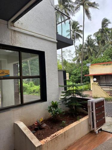 a house with a window and a garden outside at Hotel Ocean Prosper in Nagaon