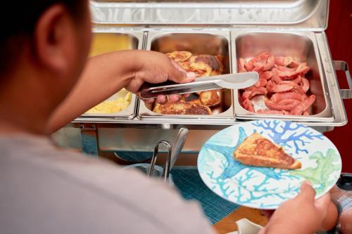 a child holding a knife and a plate of pizza at Hotel Albemarle Galapagos Beachfront in Puerto Villamil